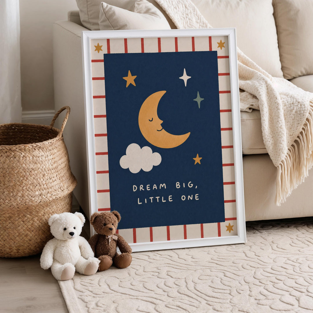 A framed poster with a crescent moon and stars, along with the text "DREAM BIG, LITTLE ONE" is displayed on a white wall in a cozy living room setting.