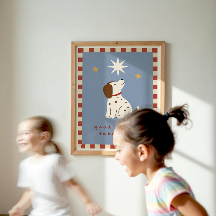Two young girls are running in front of a framed picture of a dog with a star on a blue background.