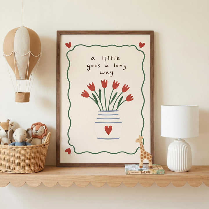 a framed picture with a vase of red flowers and a heart-shaped design, placed on a shelf next to a lamp and a basket of stuffed animals.