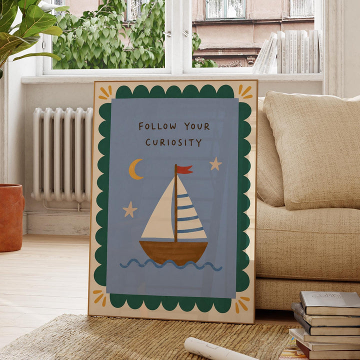 a framed poster with a sailboat illustration and the text "FOLLOW YOUR CURIOSITY" on it, placed on a rug in a room with a window and a beige couch.