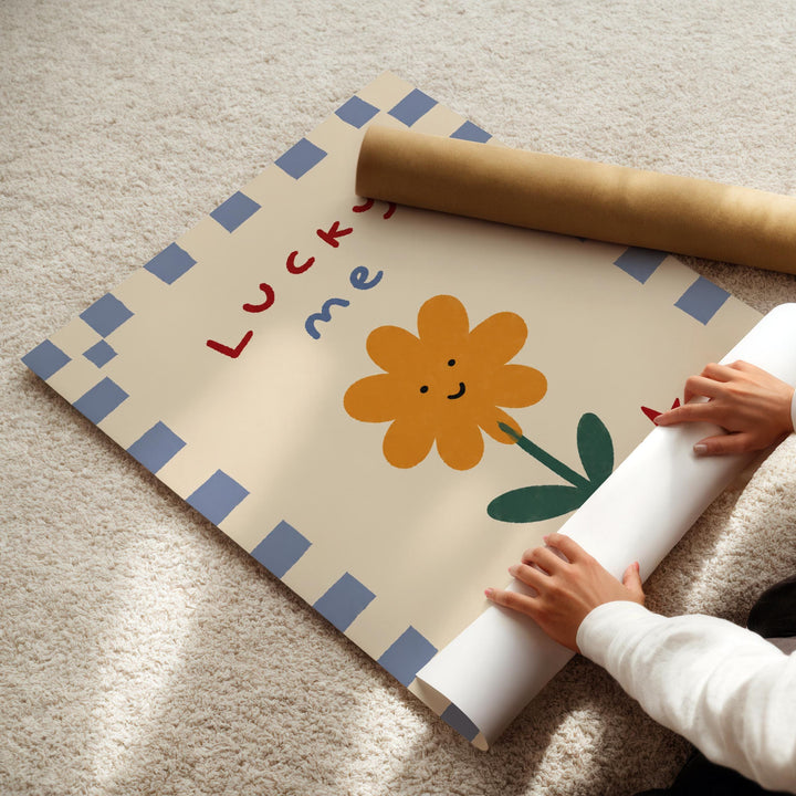A person's hands are rolling up a poster with a flower design and the text "Lucky me" on it.