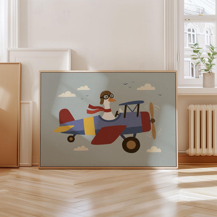 A framed illustration of a cartoon goose wearing a pilot's hat and flying a colorful airplane with clouds in the background.