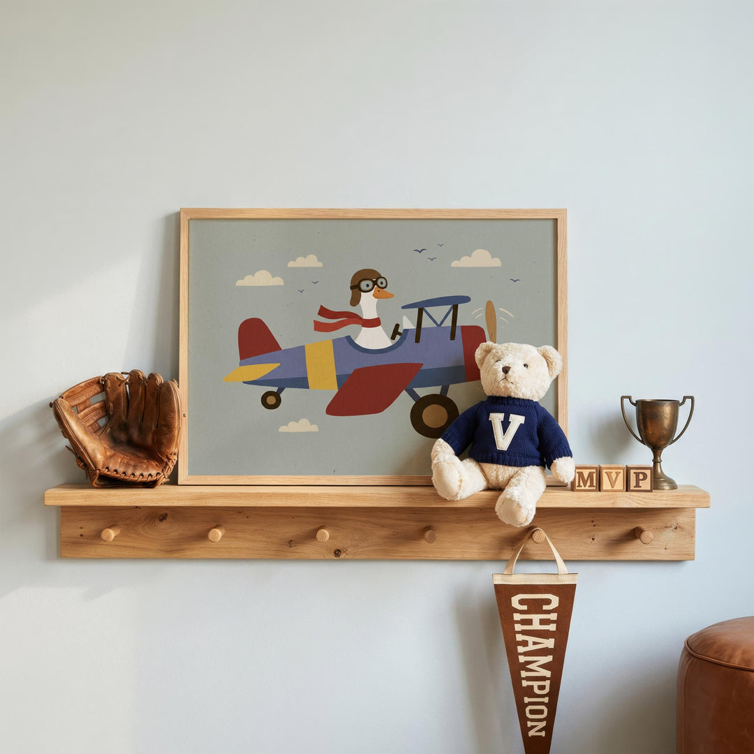a shelf with a framed picture of a penguin piloting a plane, a teddy bear, a baseball glove, and a trophy.