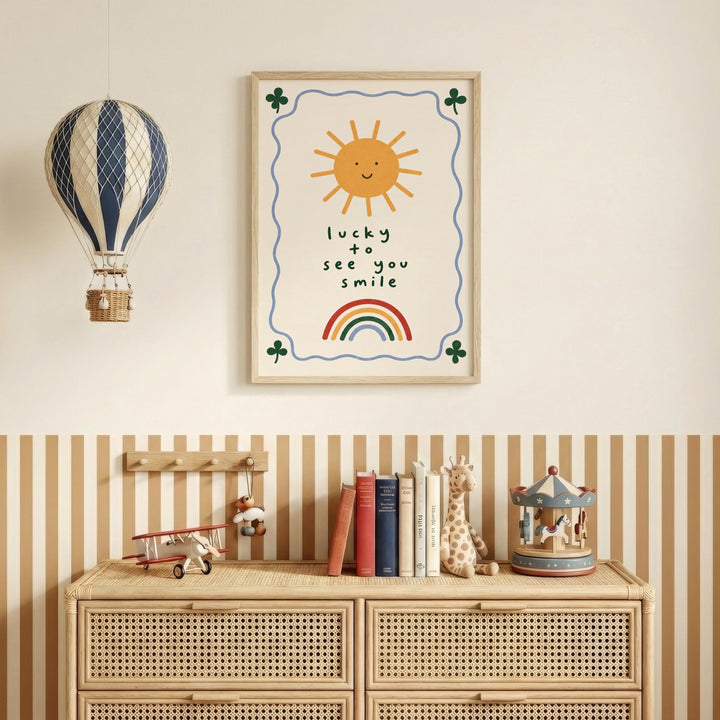 a wall with a framed poster that says "Lucky to see you smile", a hot air balloon, a wooden dresser with books and toys, and a toy carousel.