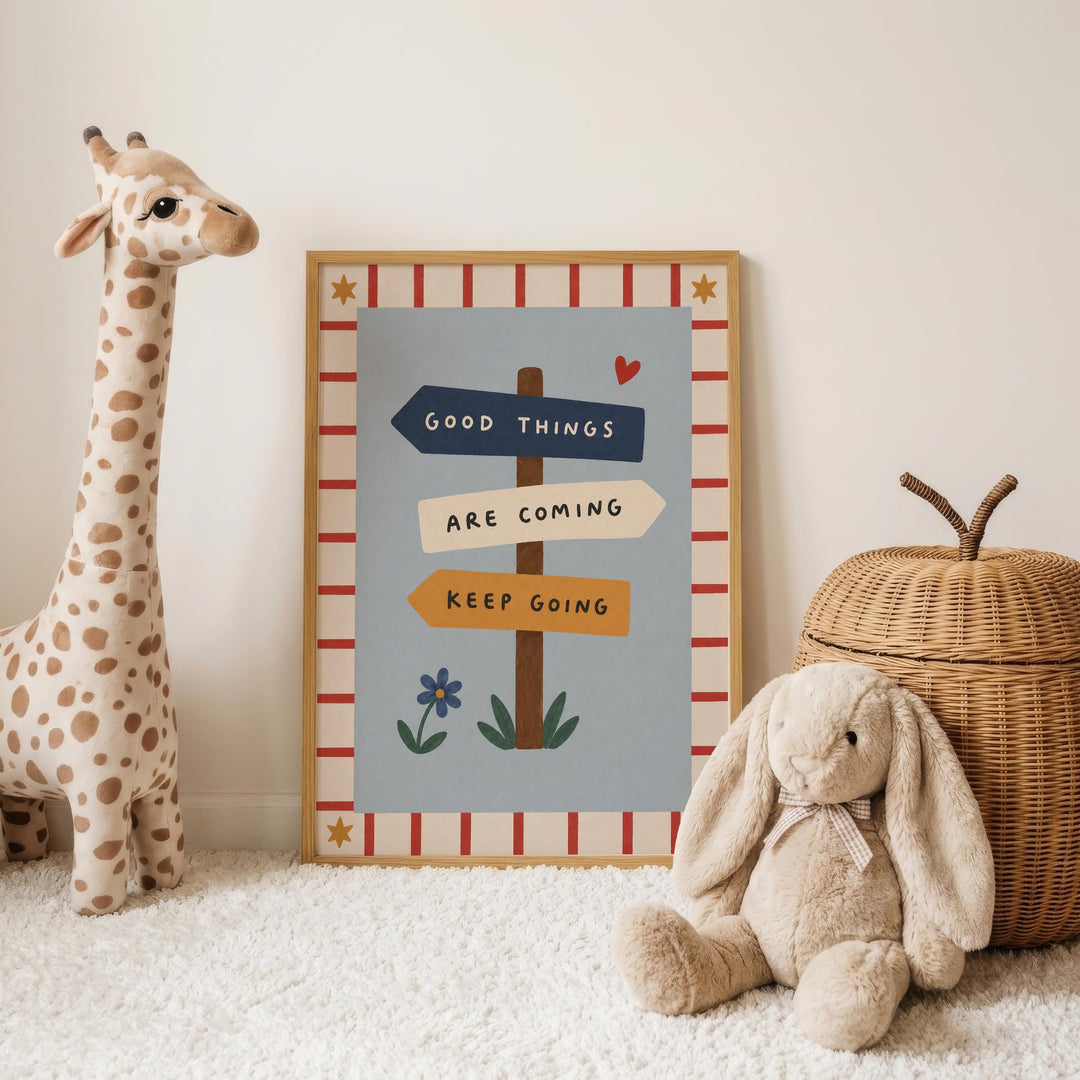 a giraffe and a stuffed rabbit, both sitting on a white carpet, with a framed sign in the background that reads "Good things are coming, keep going".