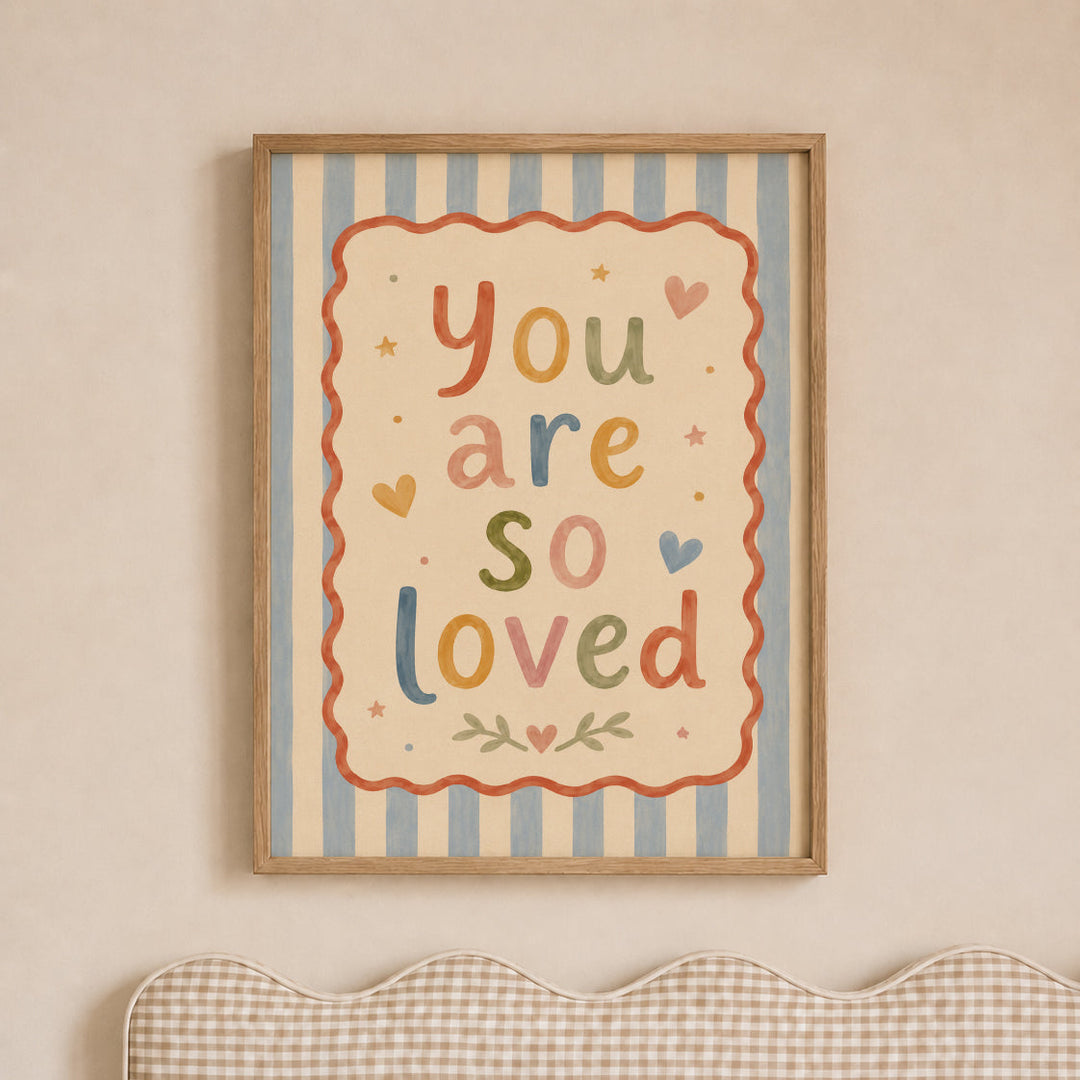 Illustrated nursery print reading 'you are so loved' in colourful folk lettering with hearts and stars