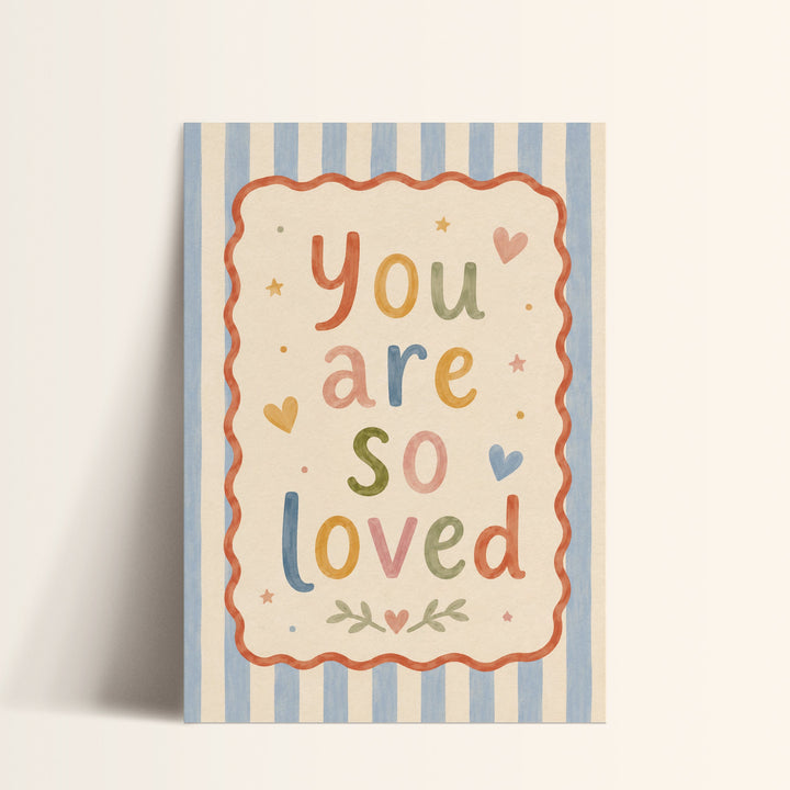 Illustrated nursery print reading 'you are so loved' in colourful folk lettering with hearts and stars