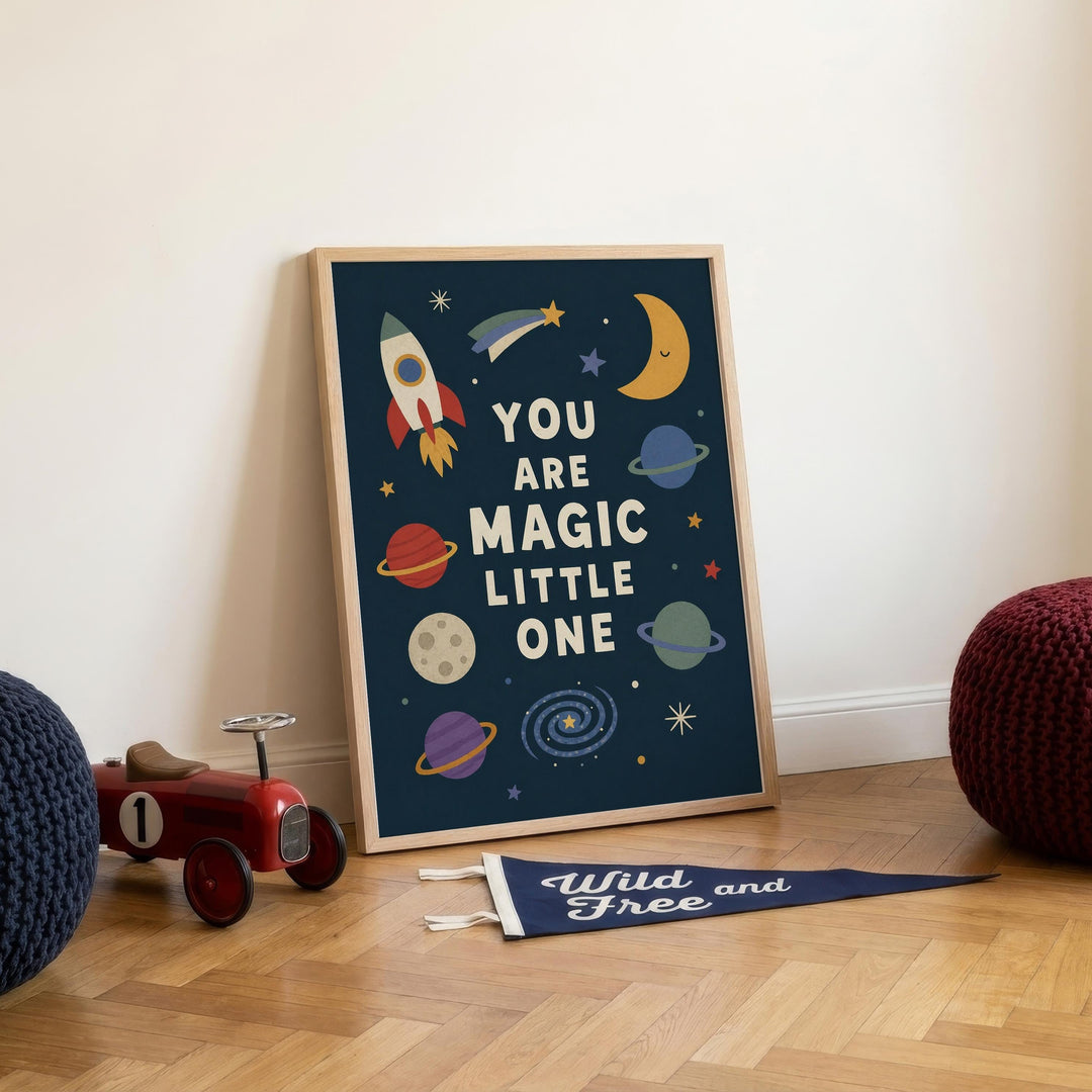 a framed poster with a space-themed design, including a rocket, planets, and a crescent moon, placed on a wooden floor next to a toy tractor.