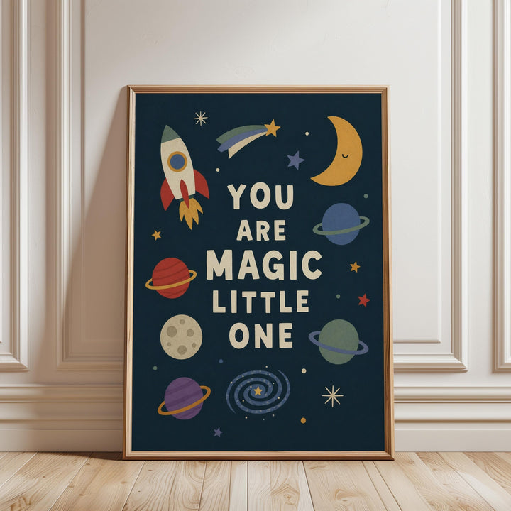 The image is a framed poster with a space-themed design, featuring a rocket ship, planets, and stars. The text on the poster reads "YOU ARE MAGIC LITTLE ONE".