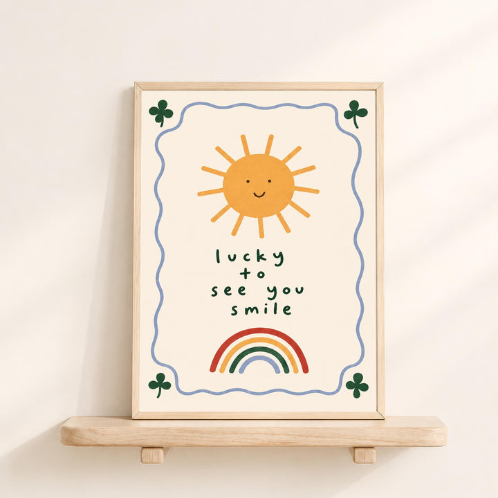 a framed poster with a cheerful sun, rainbow, and shamrock design, along with the text "lucky to see you smile".