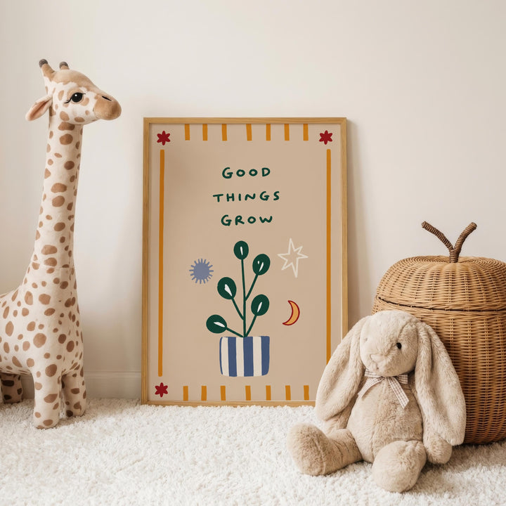 a giraffe, a rabbit, and a wicker basket, all placed on a white carpet. In the background, there is a framed poster with the text "Good THINGS GROW" and various decorative elements such as a plant, a star, and a moon.