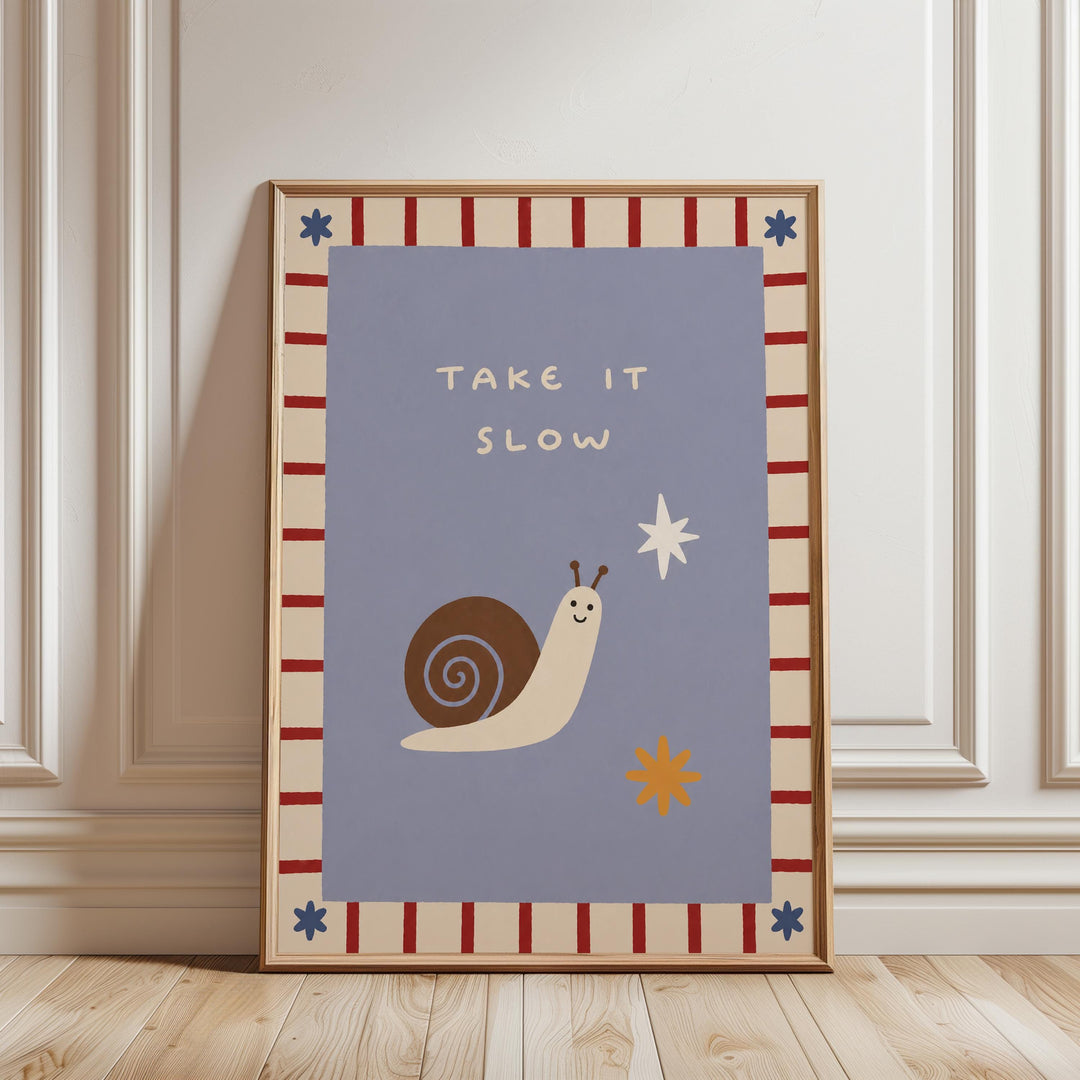a framed poster with a snail and a star on it, along with the text "TAKE IT SLOW" written on it.