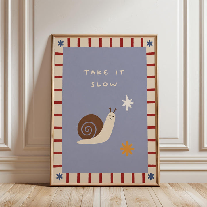 a framed poster with a snail and a star on it, along with the text "TAKE IT SLOW" written on it.