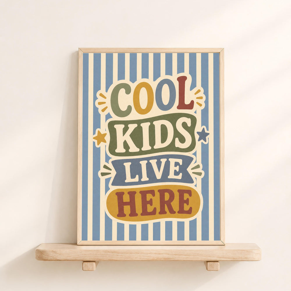 a framed poster with the text "COOL KIDS LIVE HERE" on it, displayed on a wooden shelf against a white wall.