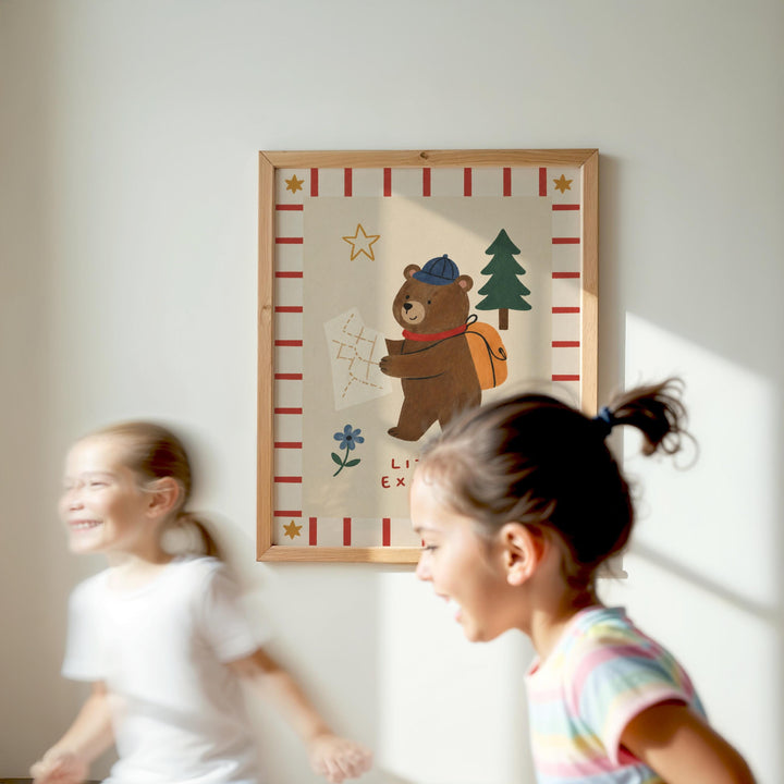 Two young girls are running in front of a framed picture of a bear on a map.
