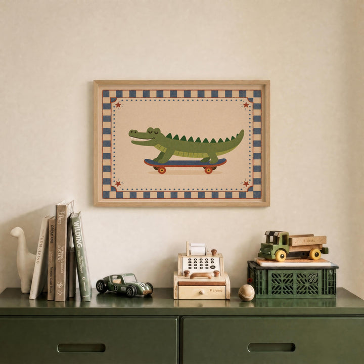 a framed picture of a green alligator riding a skateboard, displayed on a wall above a green dresser with various toys and books on it.