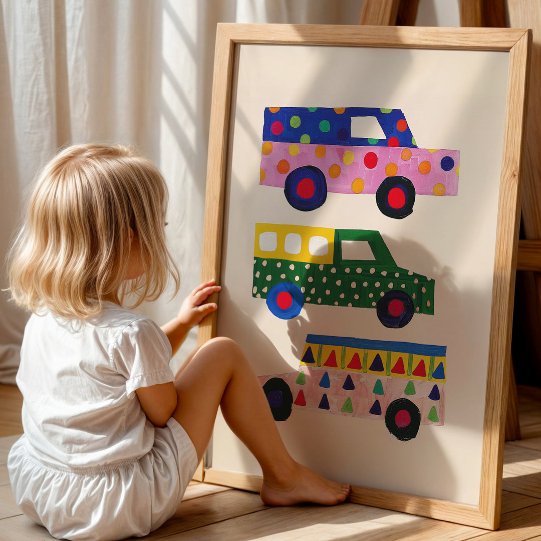 a little girl sitting on the floor next to a painting