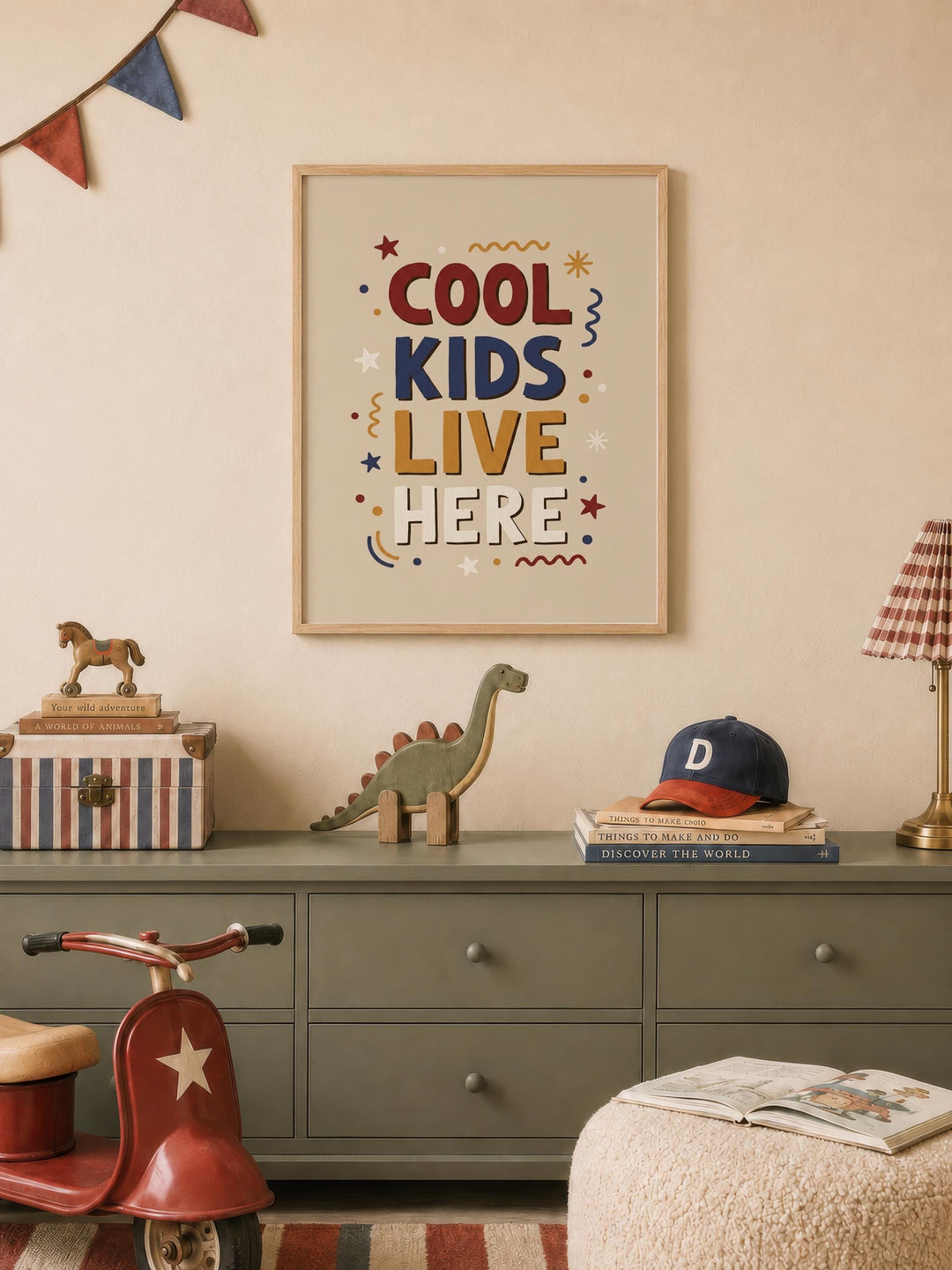 a child's bedroom with a framed poster on the wall that says "COOL KIDS LIVE HERE", a toy dinosaur, a toy horse, a stack of books, and a red toy scooter.