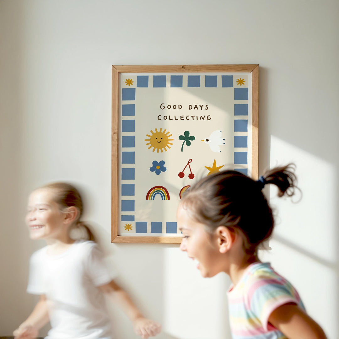 Two young girls are running in front of a framed poster with the text "Good days collecting" on a white wall.