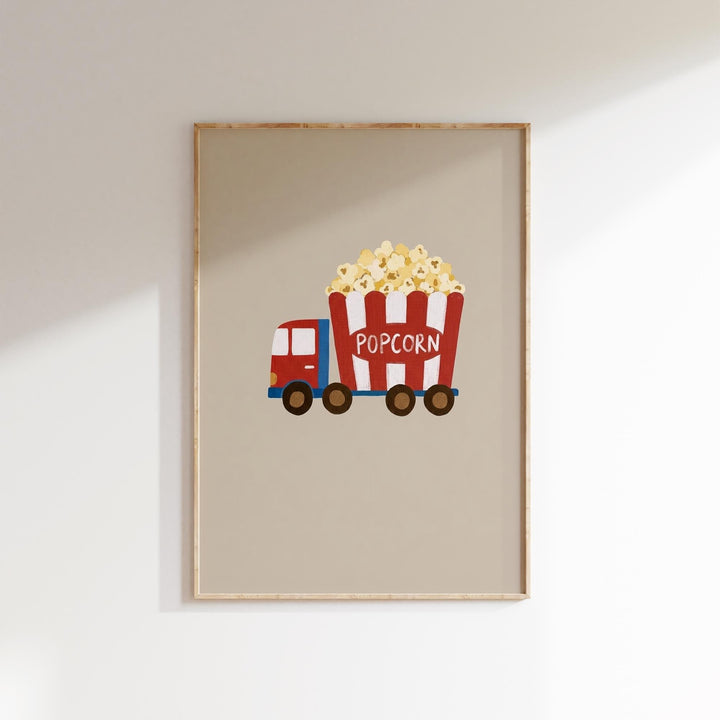 A framed illustration of a red truck with a large red and white striped bucket filled with popcorn.