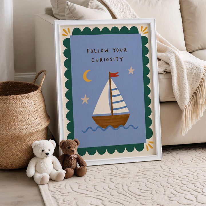 a framed poster with a sailboat illustration, placed on a carpeted floor next to a white couch. There are two teddy bears sitting on the floor in front of the poster.