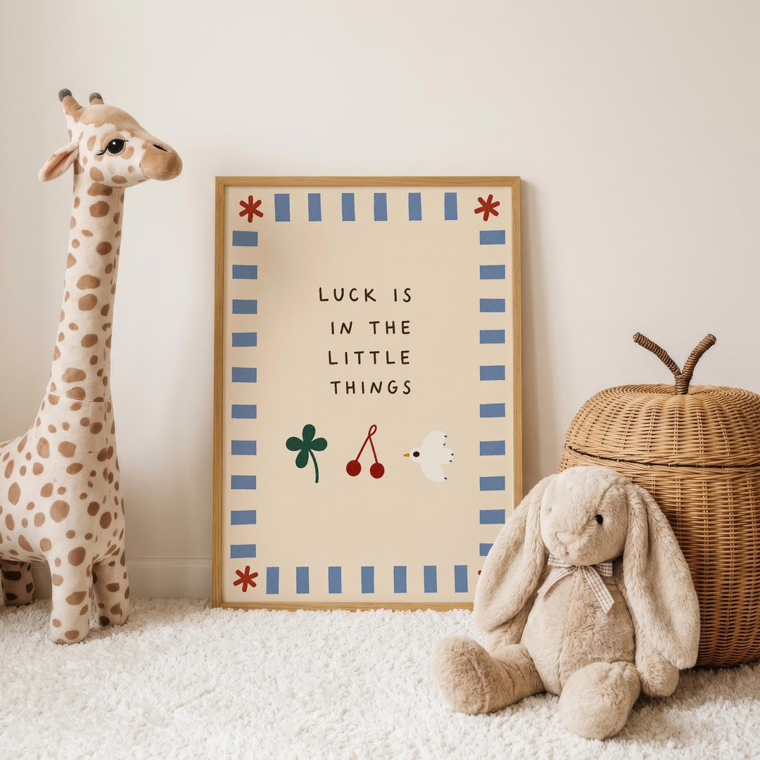 a giraffe and a stuffed rabbit, both placed next to a framed sign with the text "LUCK IS IN THE LITTLE THINGS".