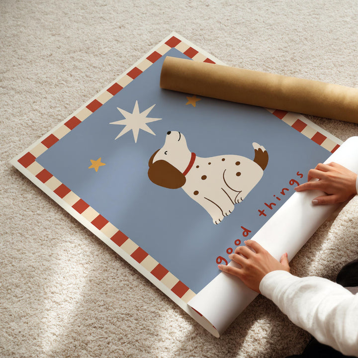 A child's hands are rolling up a poster featuring a cartoon dog and a starry night sky.
