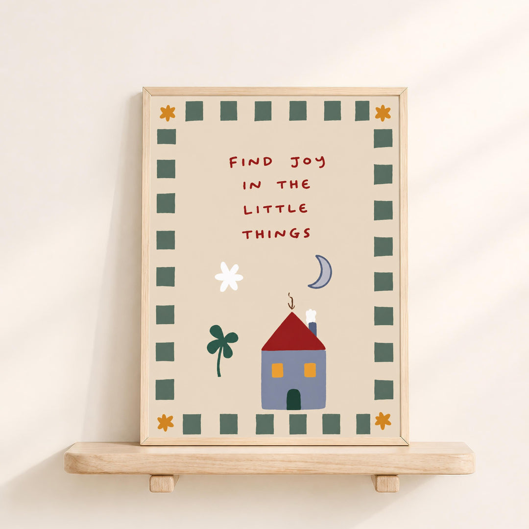 The image is a framed poster with a whimsical illustration of a house, flowers, and a moon, along with the text "Find joy in the little things" written in a playful font.