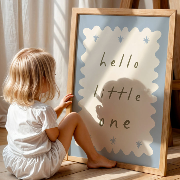a little girl sitting on the floor next to a sign