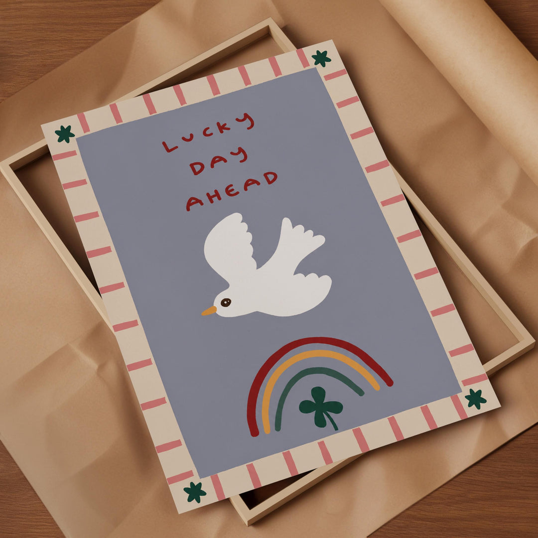 a colorful greeting card with a white bird, a rainbow, and a clover, all set against a blue background.