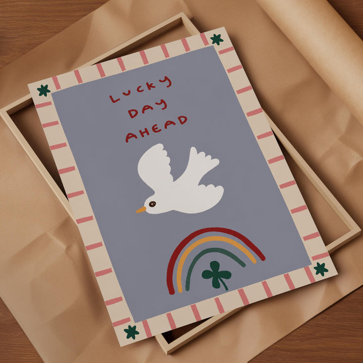 a colorful greeting card with a white bird, a rainbow, and a clover, all set against a blue background.