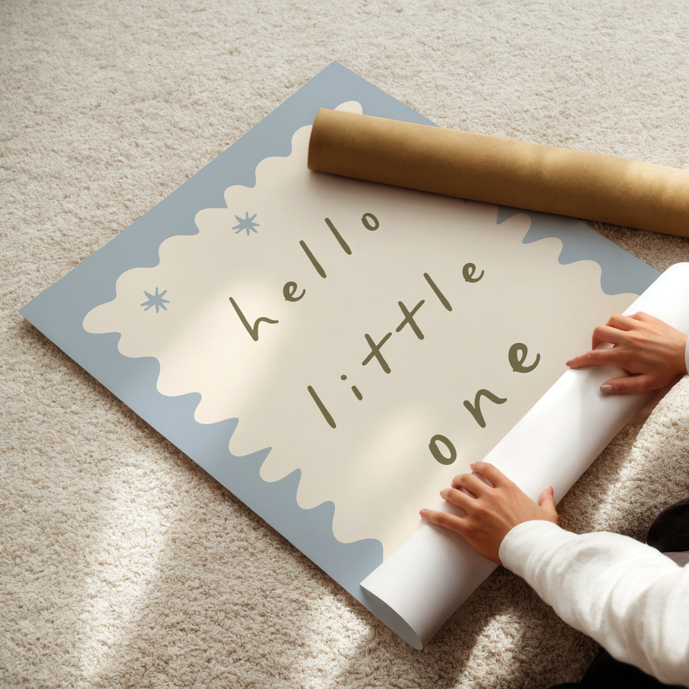 a child is holding a roll of paper with the words hello little one on it