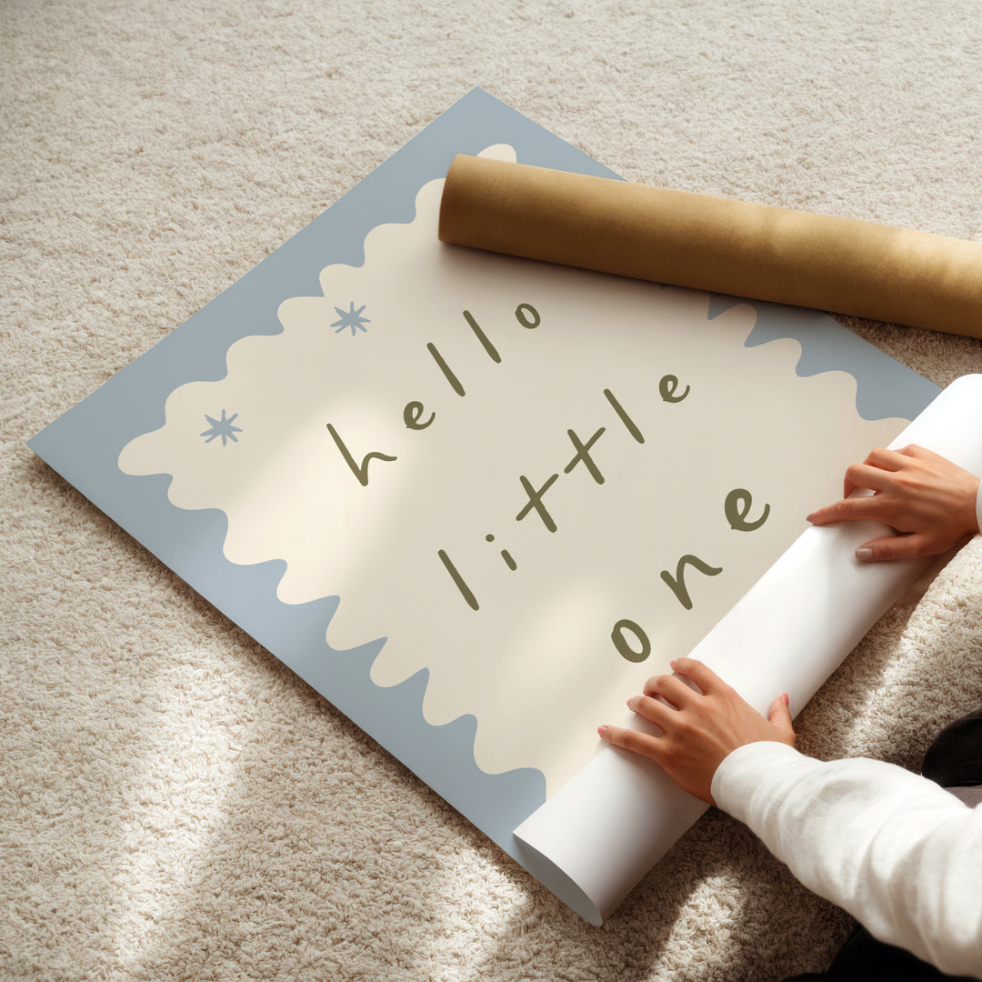 a child is holding a roll of paper with the words hello little one on it
