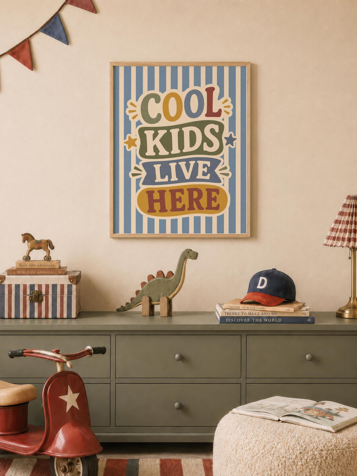 a child's bedroom with a framed poster that says "Cool Kids Live Here", a toy dinosaur, a toy horse, a stack of books, and a red toy scooter.