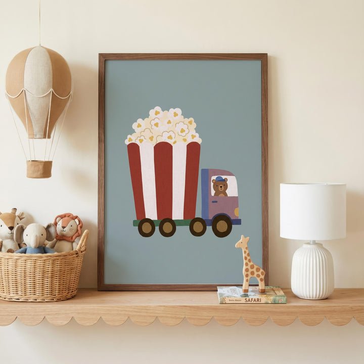 a framed picture of a red and white striped truck with a cartoon character inside, placed on a shelf next to a lamp and a basket of stuffed animals.