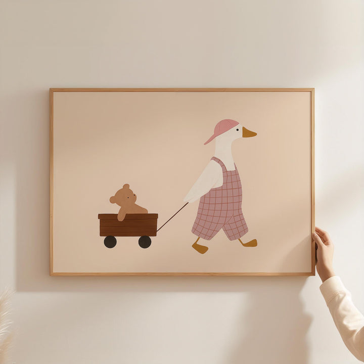 a person holding a picture of a duck pulling a teddy bear in a wagon