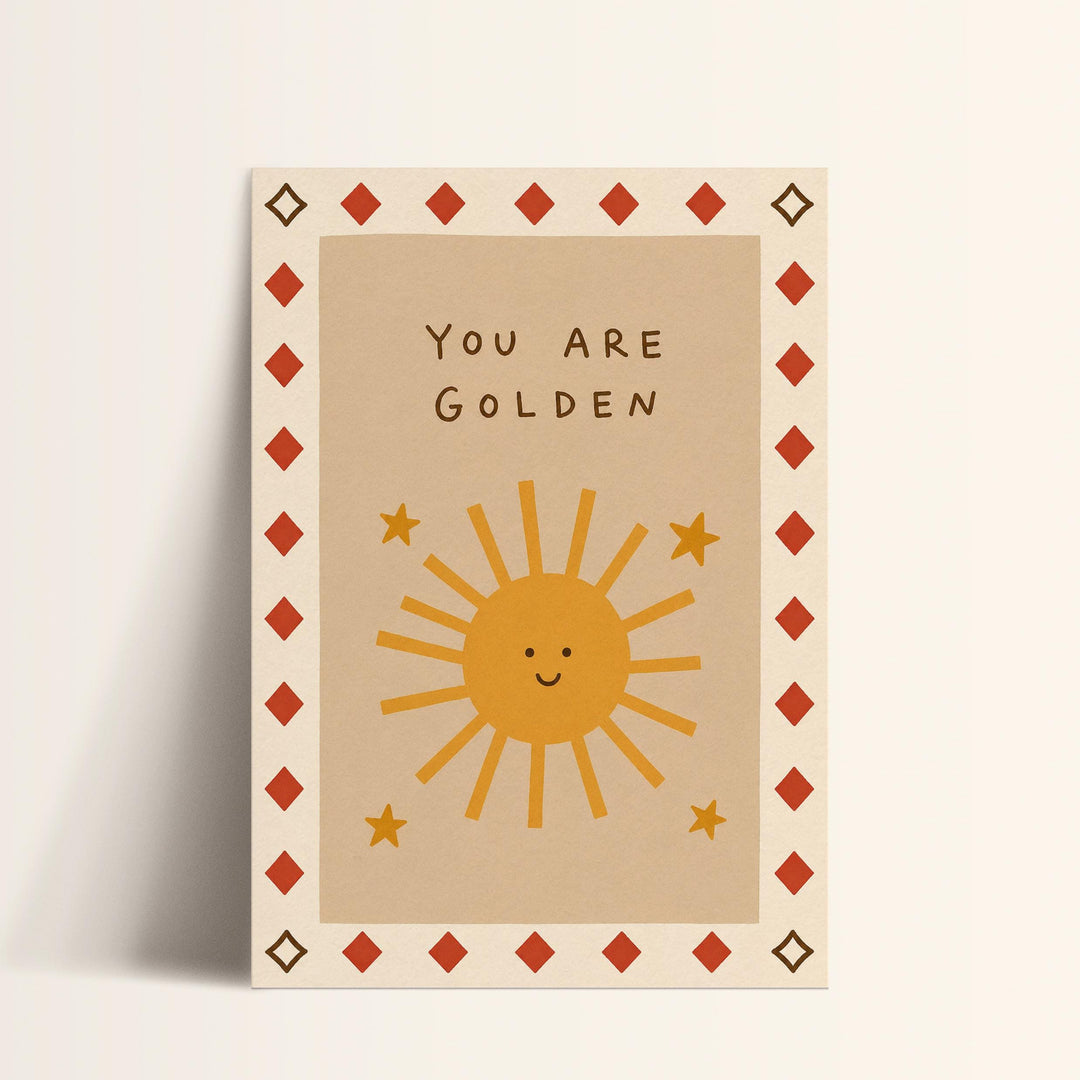 A greeting card with a sun and stars design, along with the text "You are Golden" written on it.