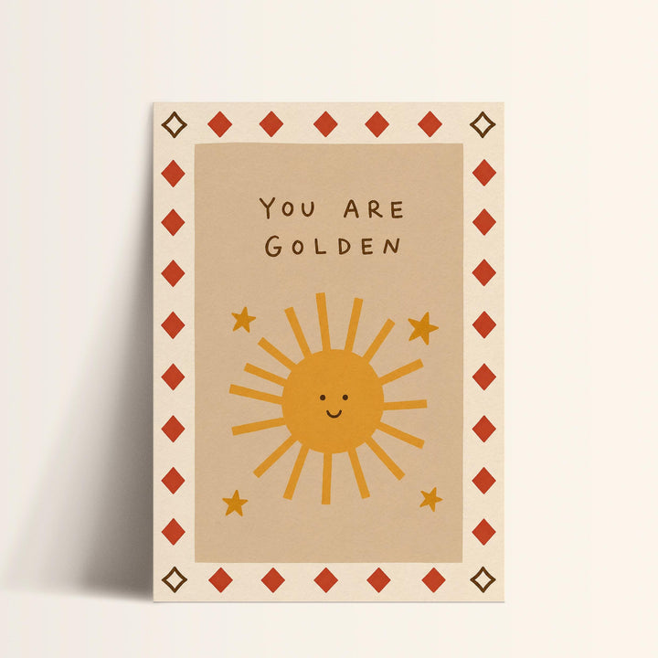A greeting card with a sun and stars design, along with the text "You are Golden" written on it.