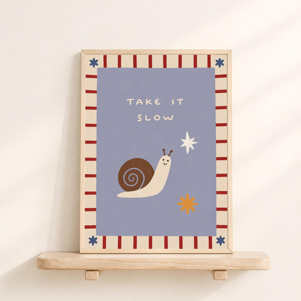 a framed poster with a snail and a star on it, along with the text "Take it slow".