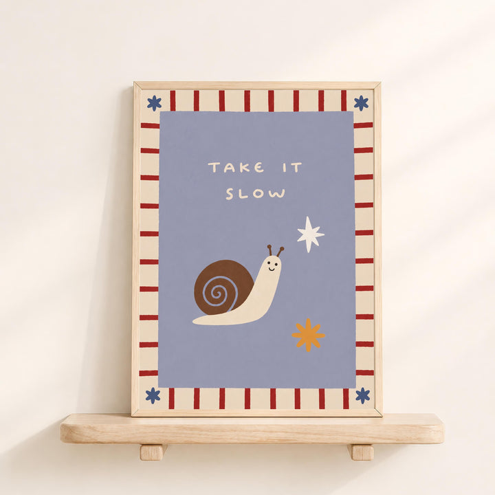 a framed poster with a snail and a star on it, along with the text "Take it slow".