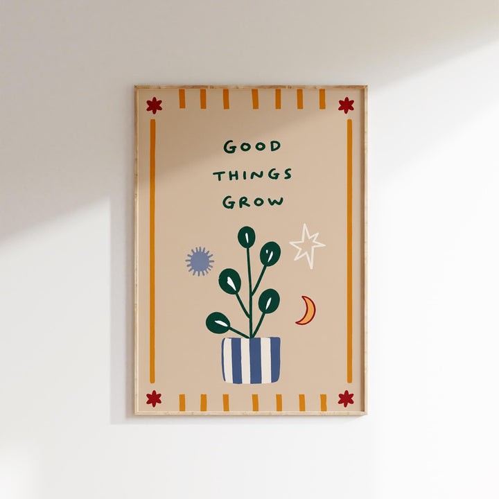 The image is a framed poster with a plant and various decorative elements, including a star, moon, and sun, along with the text "Good THINGS GROW".