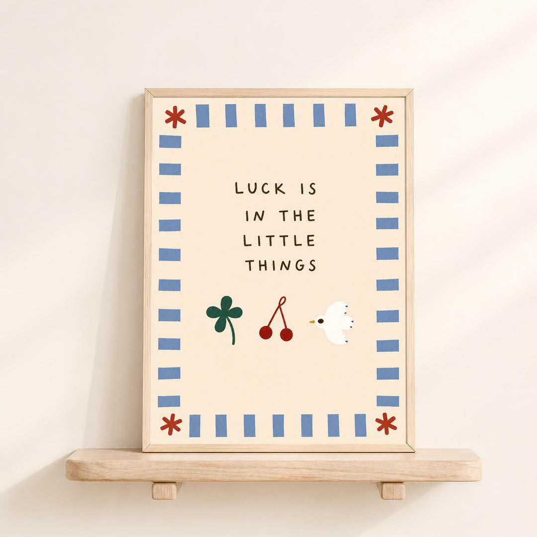 a framed poster with the text "LUCK IS IN THE LITTLE THINGS" and illustrations of a clover, a bird, and a flower.