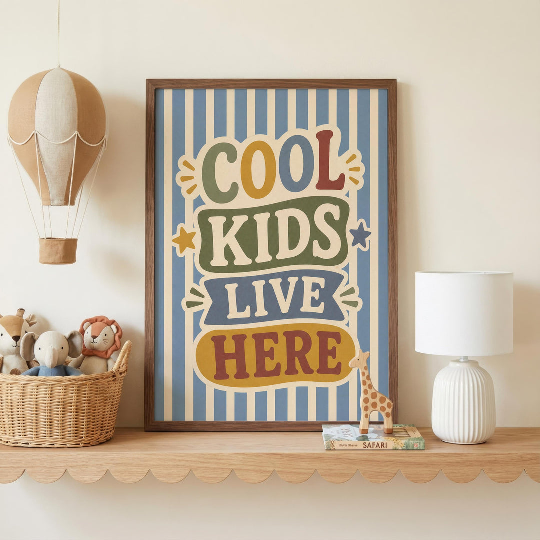 a framed poster with the text "COOL KIDS LIVE HERE" on it, placed on a shelf next to a lamp and a basket of stuffed animals.