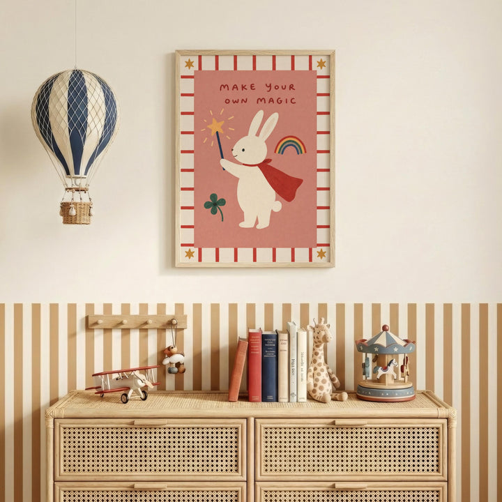 a child's bedroom with a framed poster of a rabbit holding a wand and a rainbow, a hot air balloon, and a carousel. The poster has the text "MAKE YOUR OWN MAGIC" and a rainbow. The room also includes a bookshelf with books and toys, and a striped dresser.