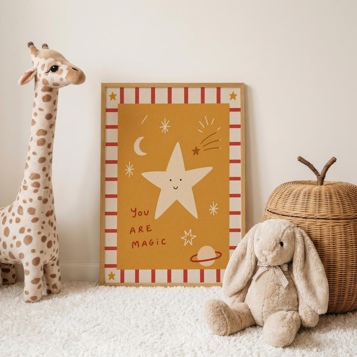 a giraffe, a stuffed rabbit, and a wicker basket, all placed on a white carpet. In the background, there is a framed picture with a star and the text "You are magic".