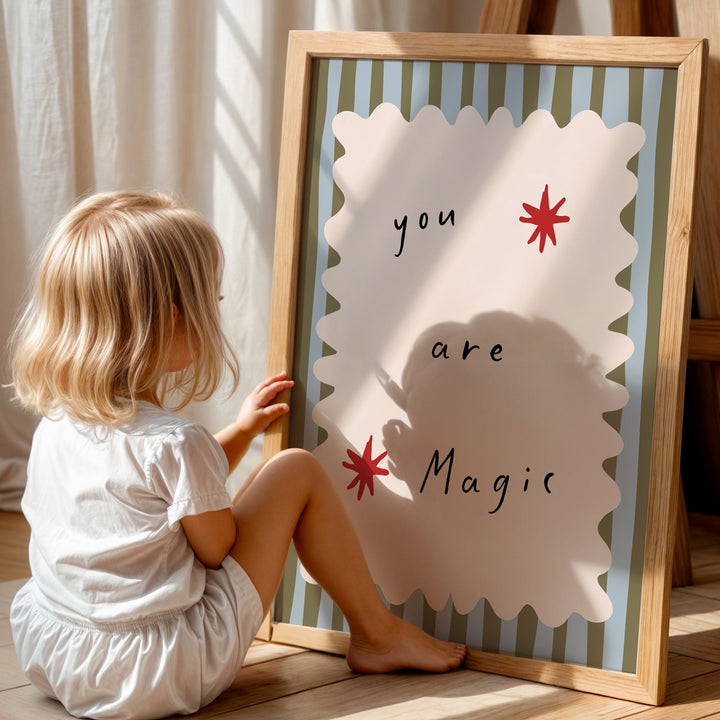 a little girl sitting on the floor next to a sign