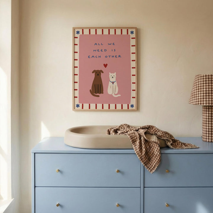 a blue dresser with a white sink on top, and a framed poster with illustrations of a dog and a cat above it.