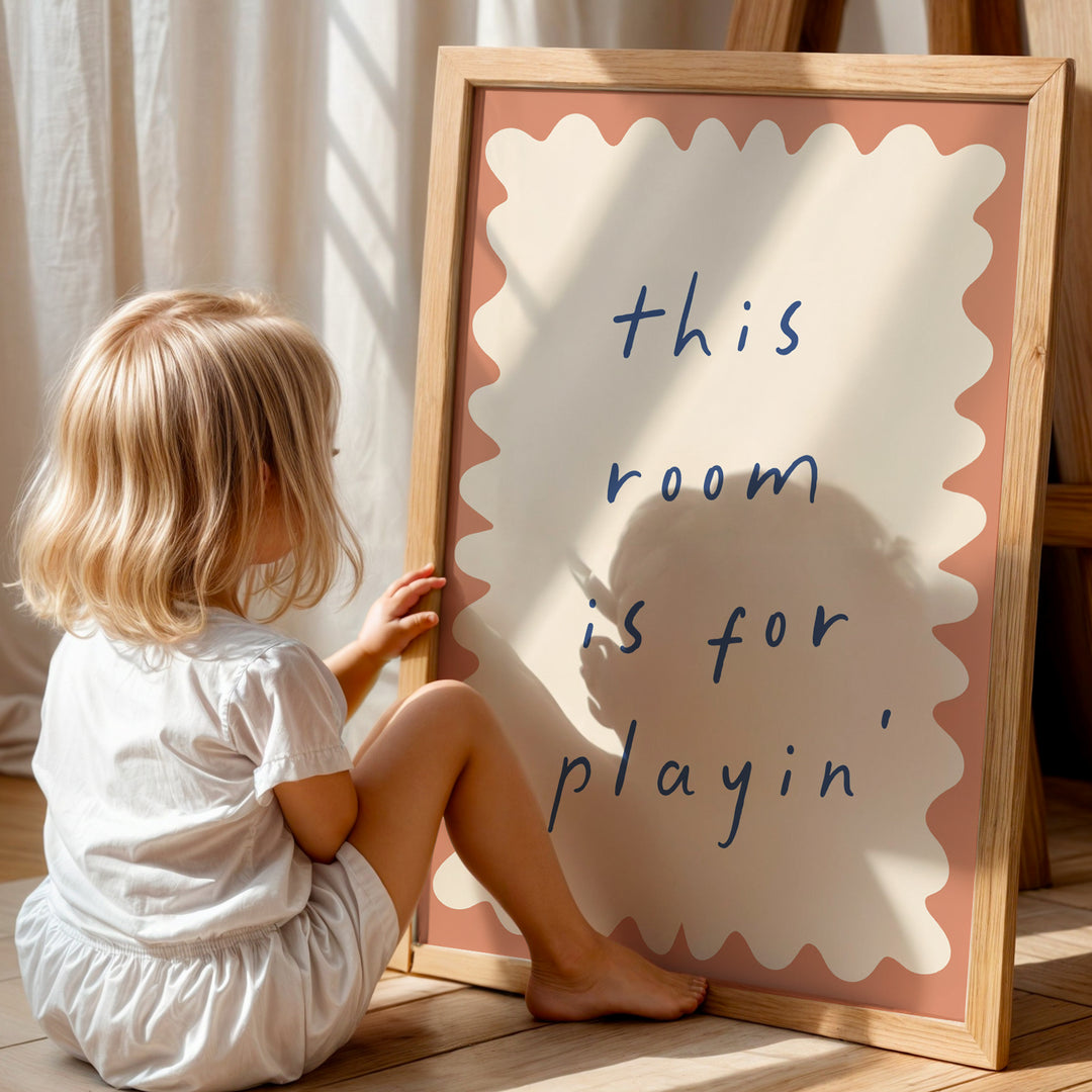 a little girl sitting on the floor next to a sign