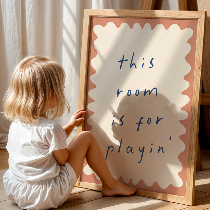 a little girl sitting on the floor next to a sign