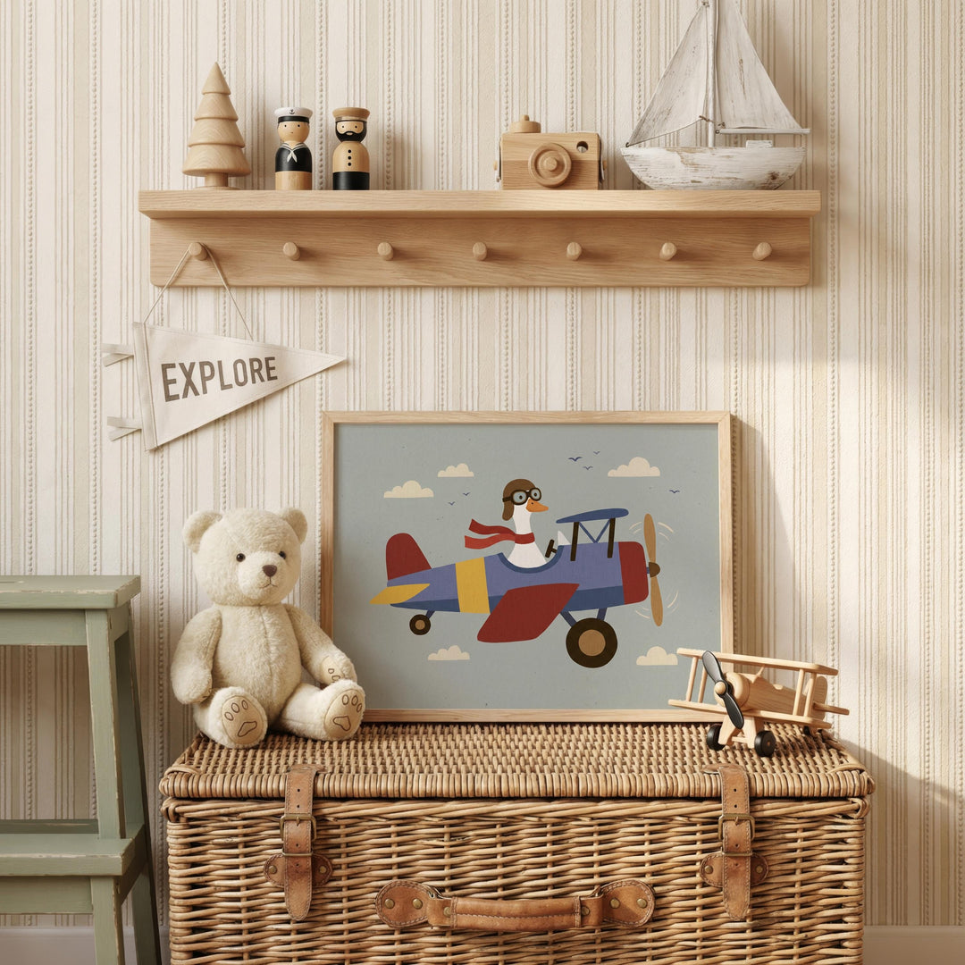 a wooden shelf with various toys and a framed picture of a teddy bear and a pilot on an airplane. The shelf has a wicker basket underneath it, and there is a teddy bear sitting on top of the basket. The framed picture depicts a pilot wearing a helmet and goggles, flying a colorful airplane. The shelf also has a small wooden toy boat and a small wooden toy airplane.